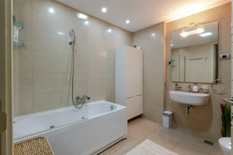 Savremeno opremljeno kupatilo sa kadom, umivaonikom i bijelim ormarićem. - image 20