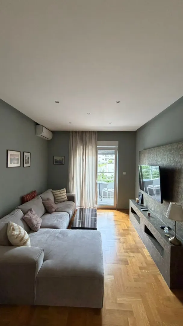 Living room with a sectional sofa, TV, and access to the terrace.