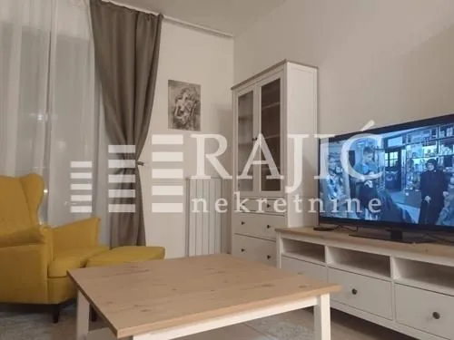 Living room with seating furniture, TV, and a white cabinet.