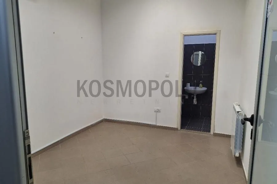 Empty room with a view of a small bathroom.