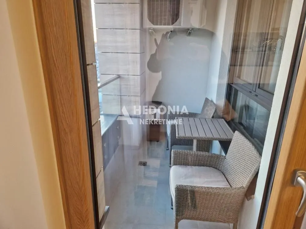 Small enclosed balcony with seating furniture.
