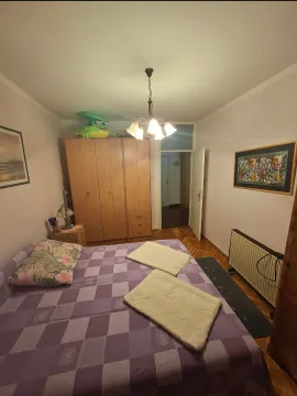 Spavaća soba sa bračnim krevetom, ormarom i slikama na zidu. - image 6