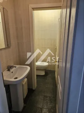 View of the bathroom with a washbasin in the foreground and a toilet in the back. - image 2