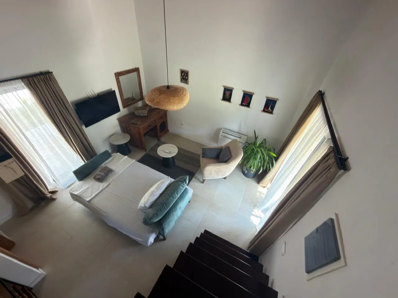 High-angle view of the living room with a bed and staircase.