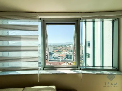 Pogled na grad i brda kroz otvoreni prozor sa roletnama. - image 4