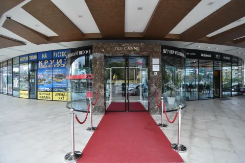 Main entrance of a commercial and residential building with a red carpet. - image 19