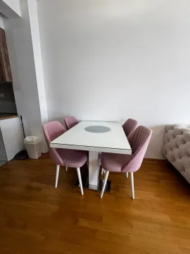 Dining area with a white table and pink chairs. - image 3