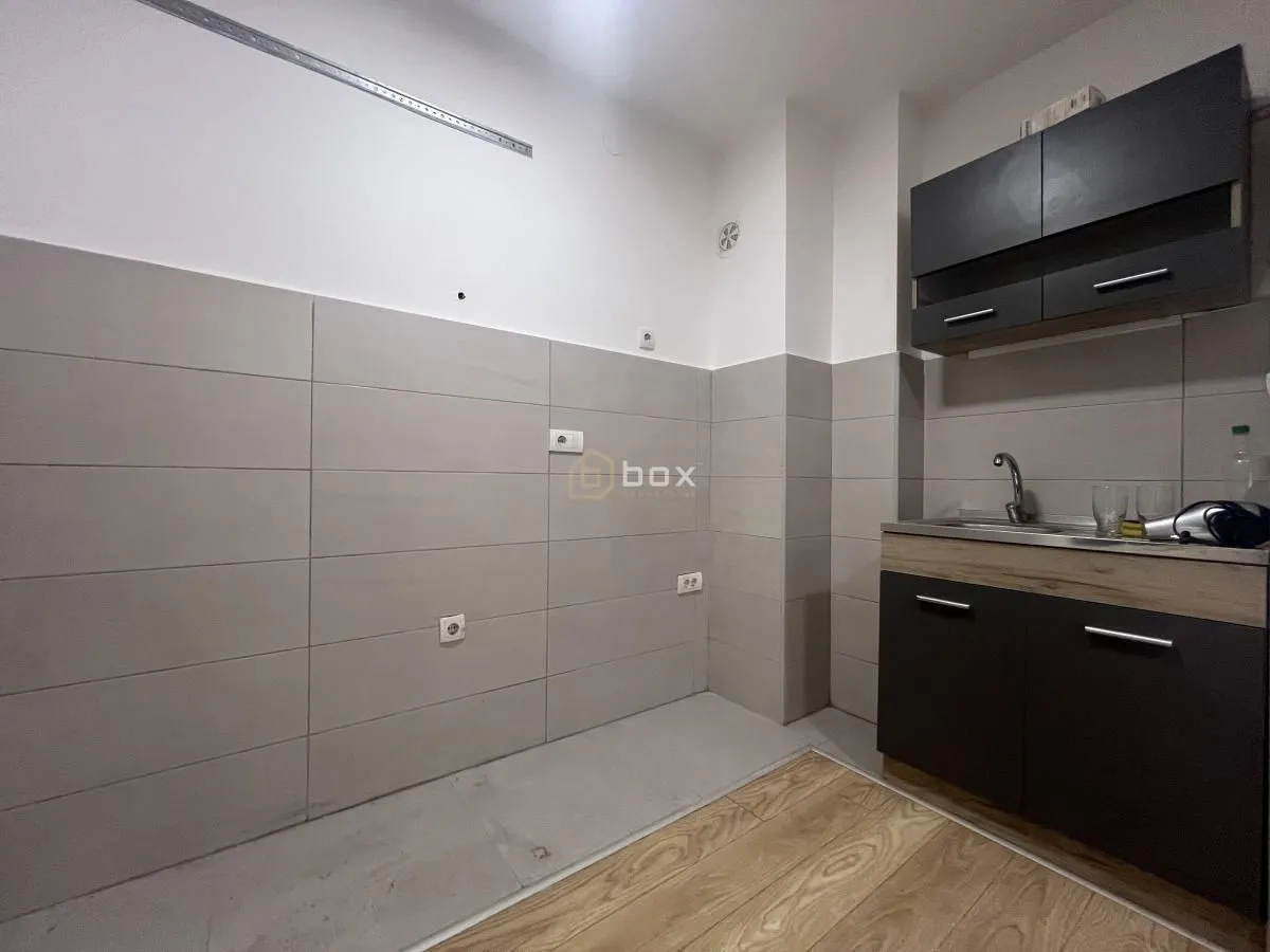 Small kitchen with dark cabinets and a sink.