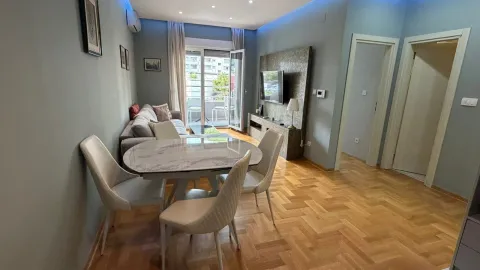 Living room with a dining area, sofa, and balcony access. - image 11