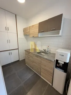 Smaller kitchen with wooden cabinets and a water dispenser. - image 8