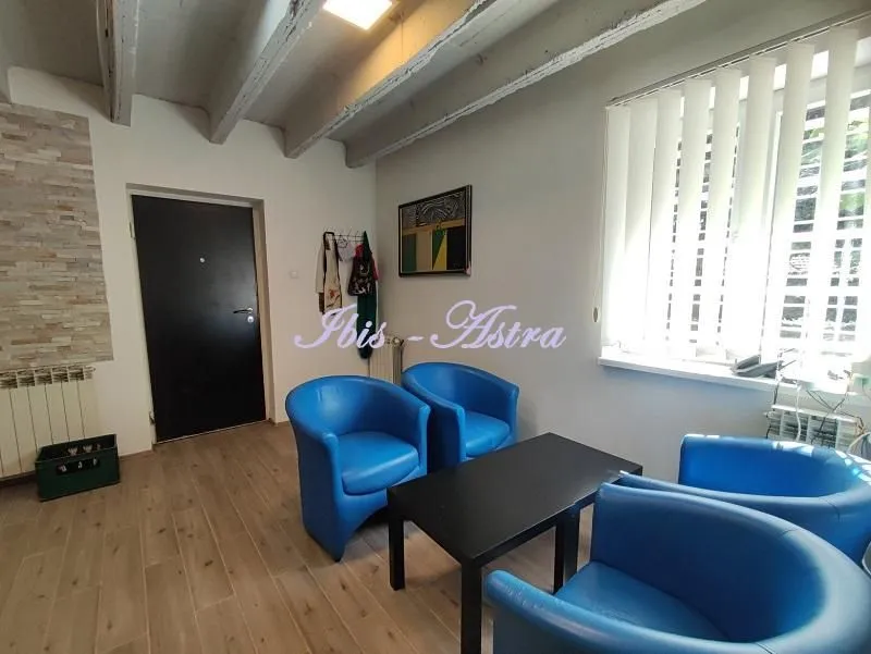 Smaller living room with blue armchairs, a coffee table, and an entrance door.