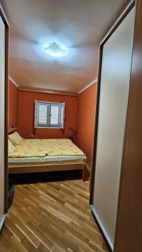 Spavaća soba sa bračnim krevetom i drvenim podom. - image 11