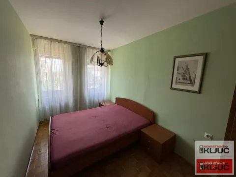 Spavaća soba sa bračnim krevetom, noćnim stočićima i prozorom sa zavesama. - image 5