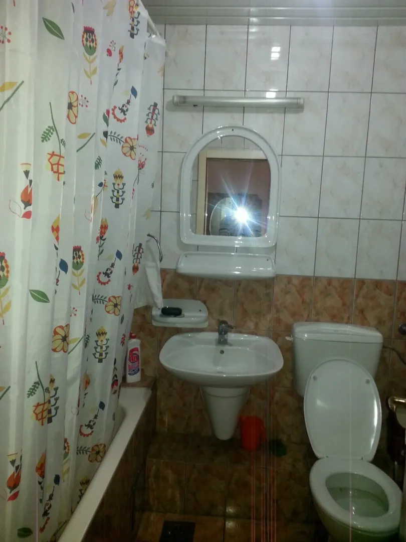 Jednostavno kupatilo sa lavaboom, ogledalom i toaletom.