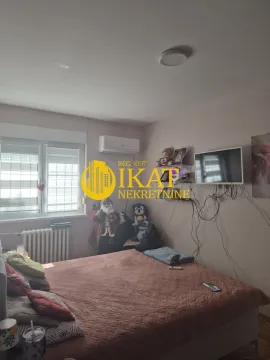 Nameštena spavaća soba sa bračnim krevetom, prozorom i televizorom na zidu. - image 12