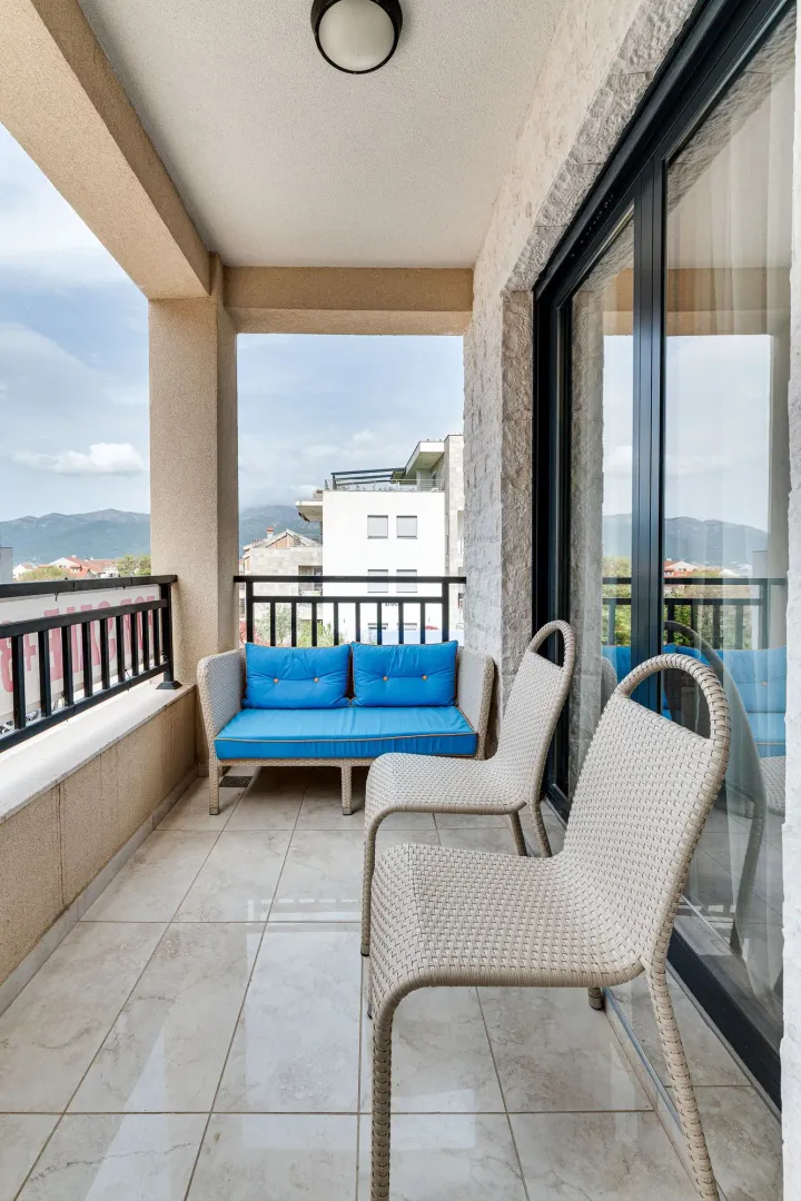 Natkriveni balkon sa garniturom za sjedenje i pogledom na okolinu.