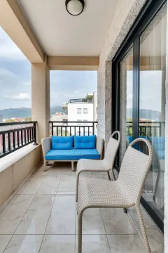 Natkriveni balkon sa garniturom za sjedenje i pogledom na okolinu. - image 11