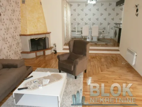 Spacious living room with a sofa, fireplace, and dining area in the background. - image 3
