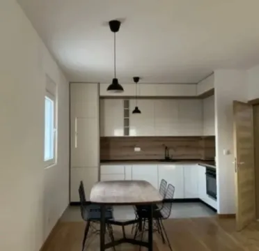 Modern kitchen with a dining table and white cabinetry. - image 3
