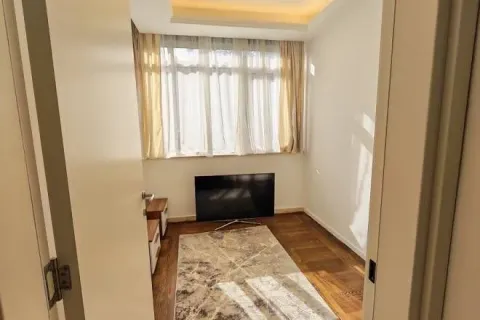 View from the hallway into a small room with a window and a TV on the floor. - image 13