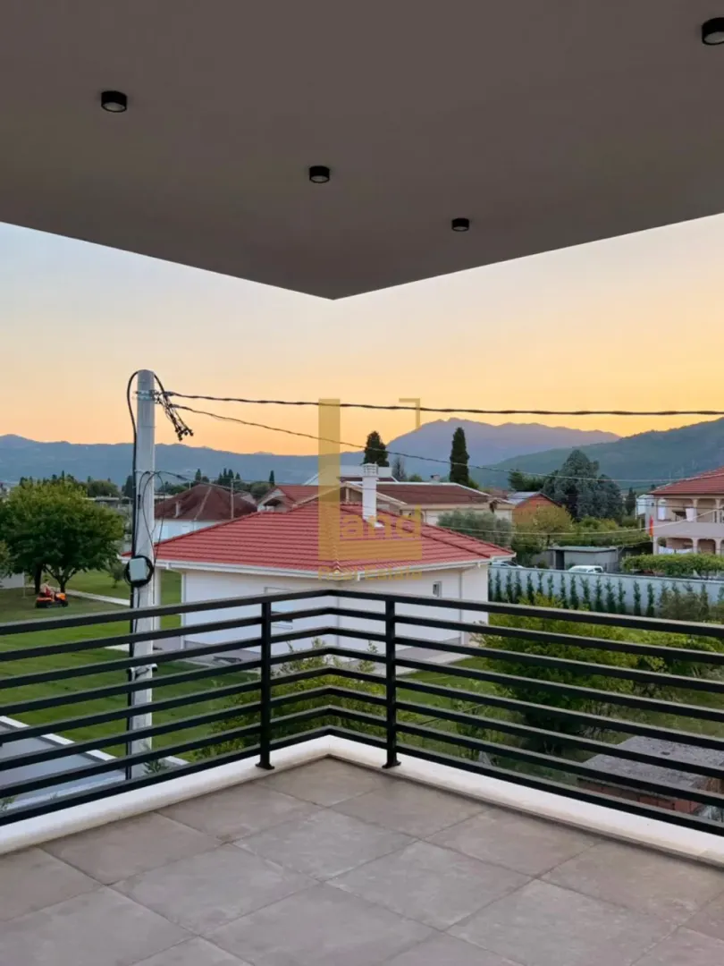 Pogled sa terase na naselje i planine u pozadini.