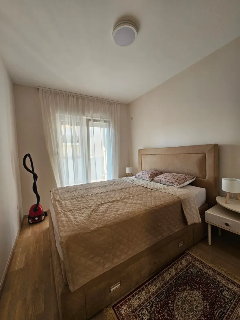 Furnished bedroom with a double bed and a window.