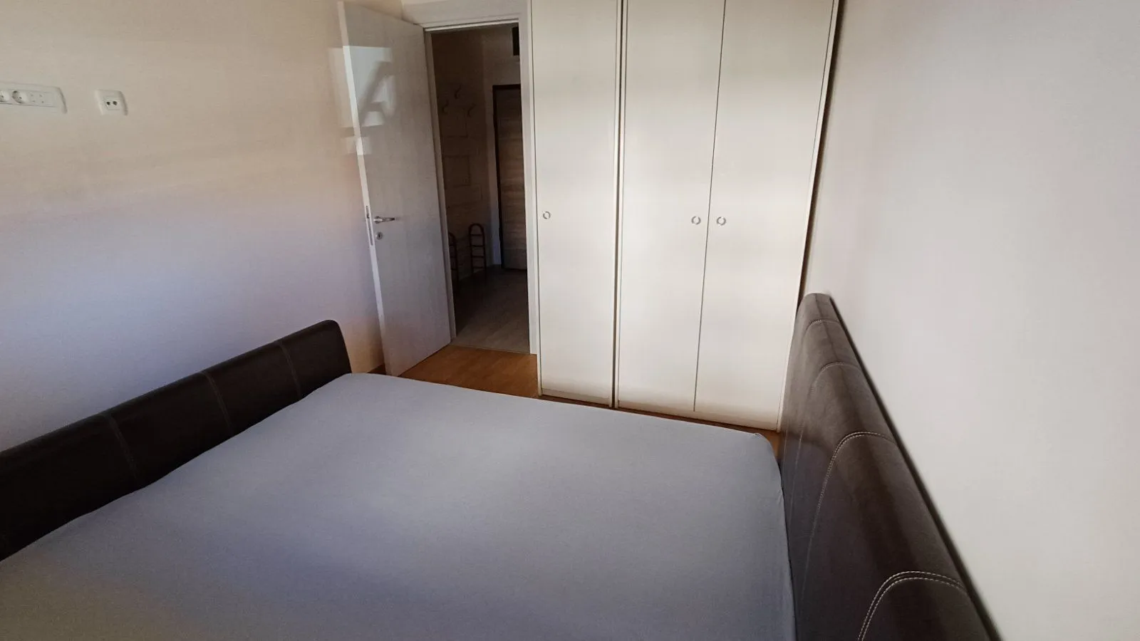 Furnished bedroom with a double bed and a fitted wardrobe.