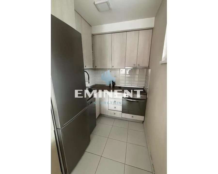 Small kitchen with light wood cabinetry and a refrigerator.