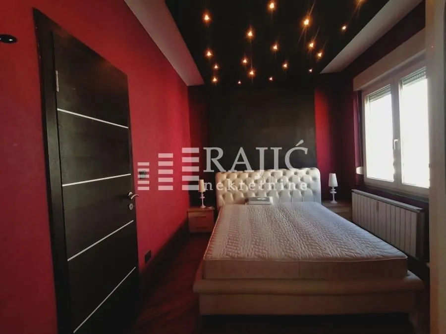 Modern bedroom with a double bed and decorative ceiling lighting.