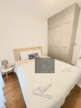 Bedroom with a double bed, white linens, and a built-in wardrobe. - image 8