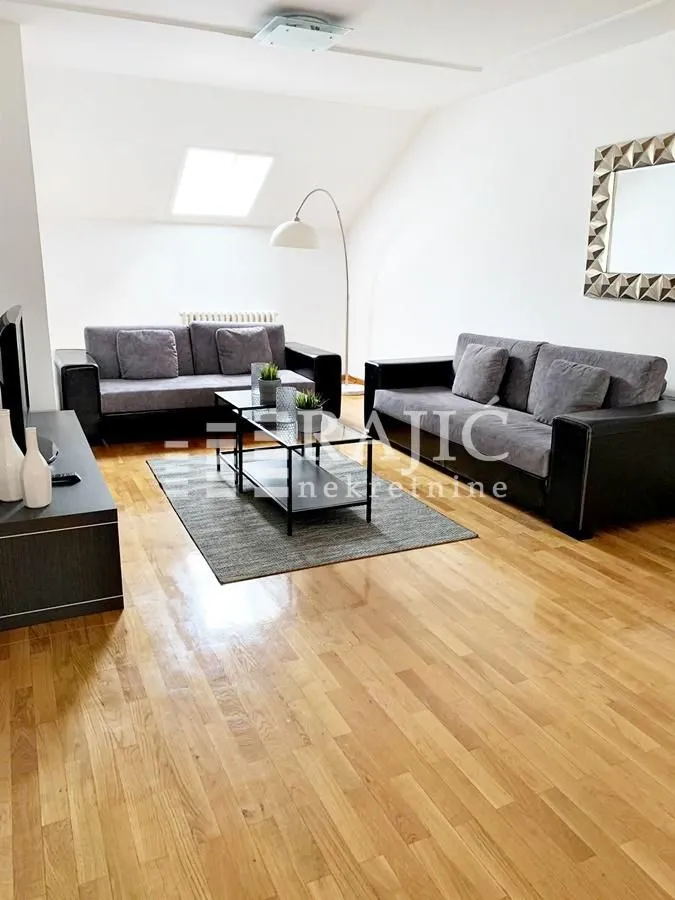 Spacious living room with a sofa set and parquet flooring.