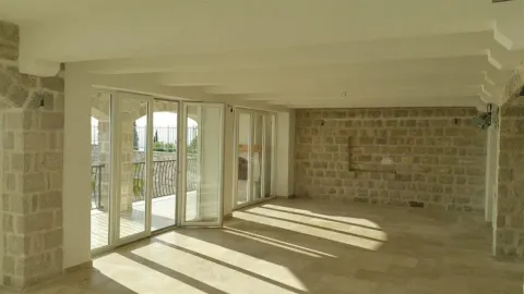 Spacious empty room with stone walls and large glass doors. - image 15