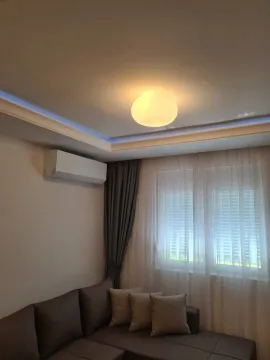 Cozy living room with a sofa, air conditioner, and window. - image 4
