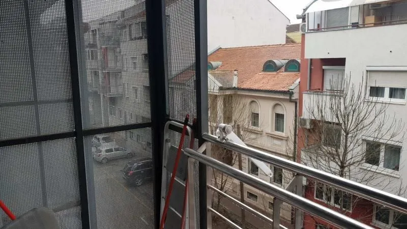 Pogled sa balkona na okolne zgrade i ulicu.