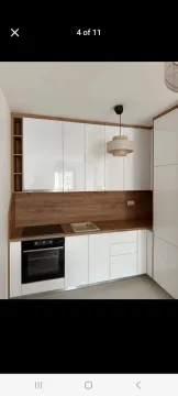 Moderna kuhinja sa bijelim elementima i drvenim radnim dijelom. - image 5