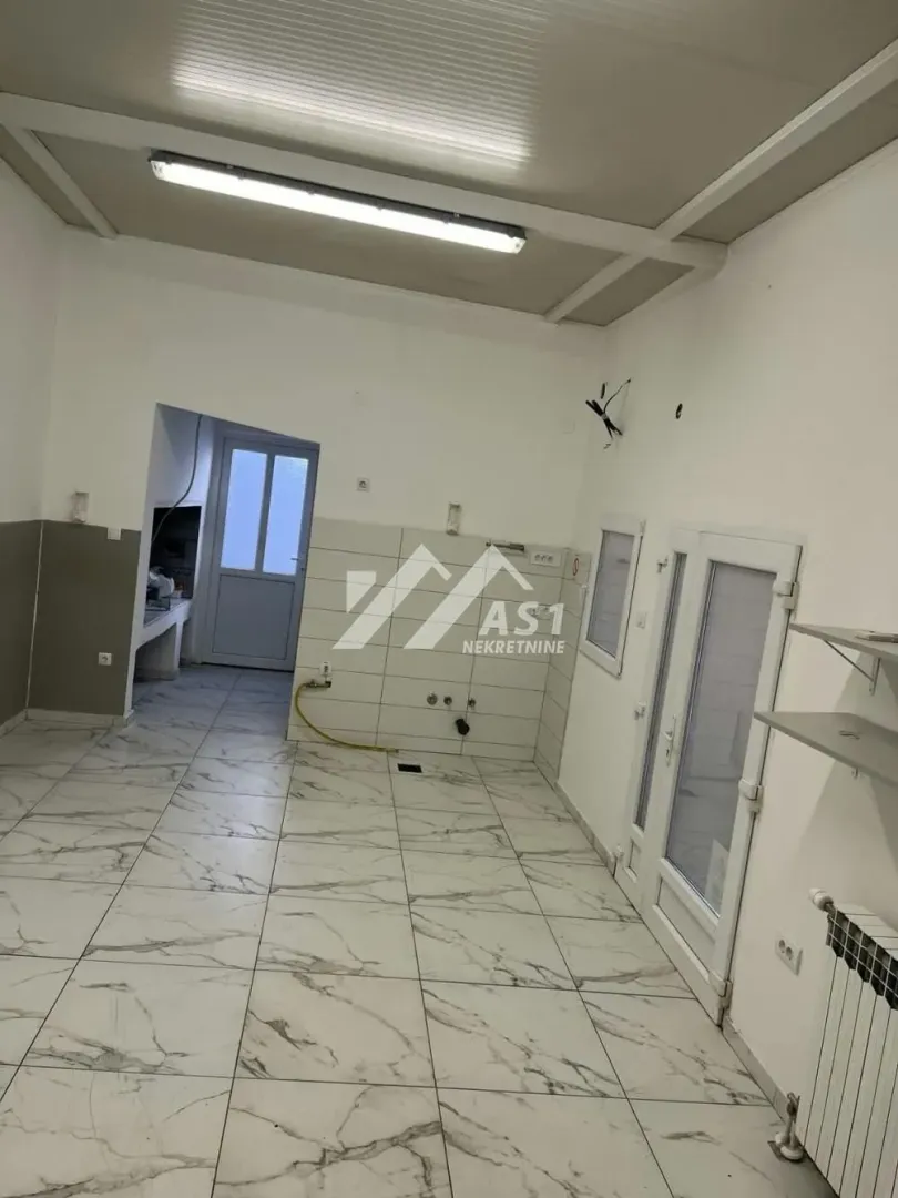 Empty kitchen with tiled floor and walls.