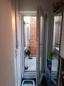 Pogled kroz otvorena vrata na malu terasu sa ciglastim zidovima. - image 5