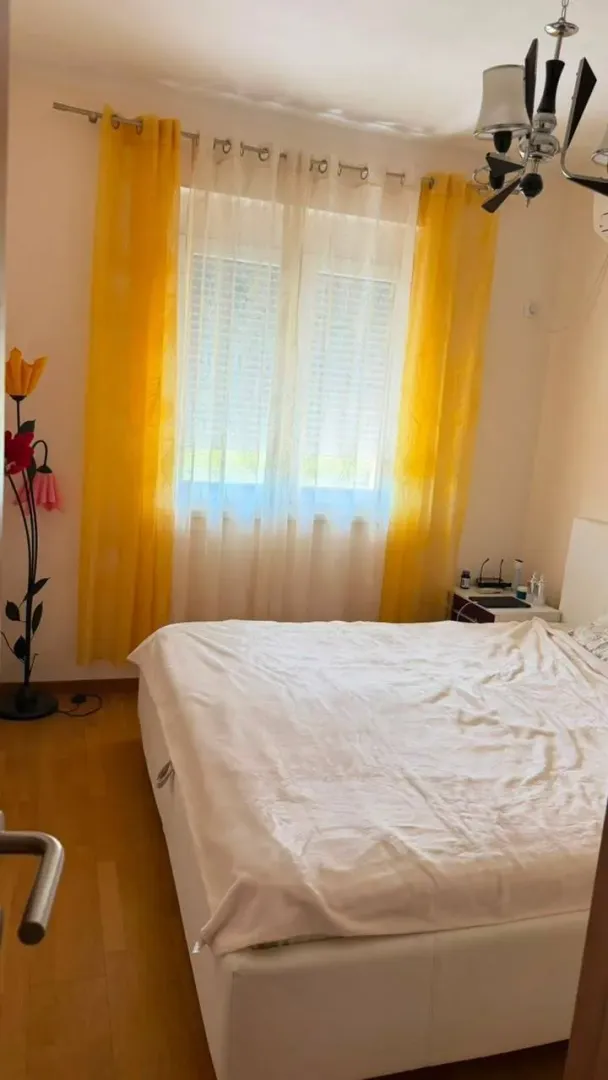 Bedroom with a double bed and yellow curtains.