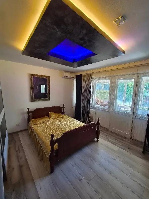 Bedroom with a double bed, wooden flooring, and decorative ceiling lighting.