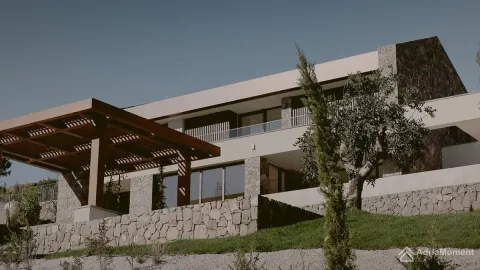 Pogled na spoljašnjost moderne vile sa kamenom fasadom i uređenim dvorištem. - image 12