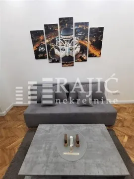 Living room with a grey sofa, coffee table and wall art. - image 4