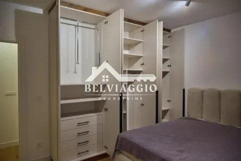 Bedroom with a double bed and a large built-in wardrobe with open doors. - image 13