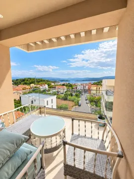 Natkriveni balkon sa garniturom za sjedenje i pogledom na naselje i more. - image 2