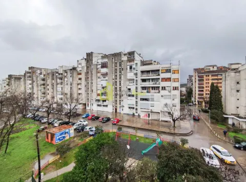 Pogled sa prozora na okolne zgrade, parking i zelenu površinu. - image 12
