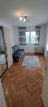 Smaller bedroom with a pull-out sofa, wardrobe and parquet flooring. - image 3