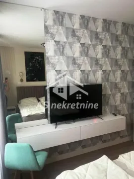 Bedroom with a double bed, wall-mounted TV, and modern wallpaper. - image 16
