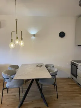 Dining area with table, chairs and lighting in a modern apartment. - image 10