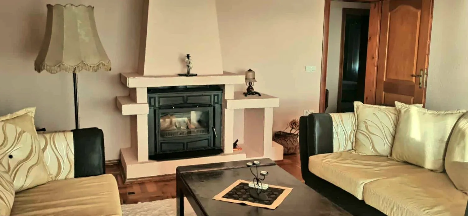 Living room with a sofa set, fireplace, and wooden coffee table.