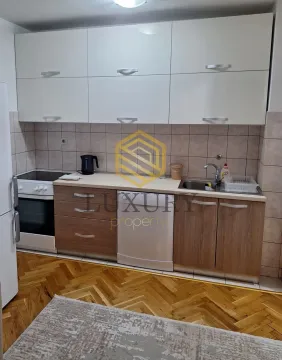 View of the kitchen with upper and lower cabinets and parquet flooring. - image 7