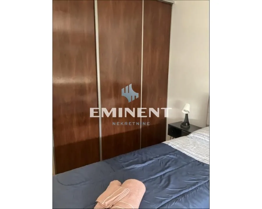 Bedroom with a large wooden wardrobe and a bed.